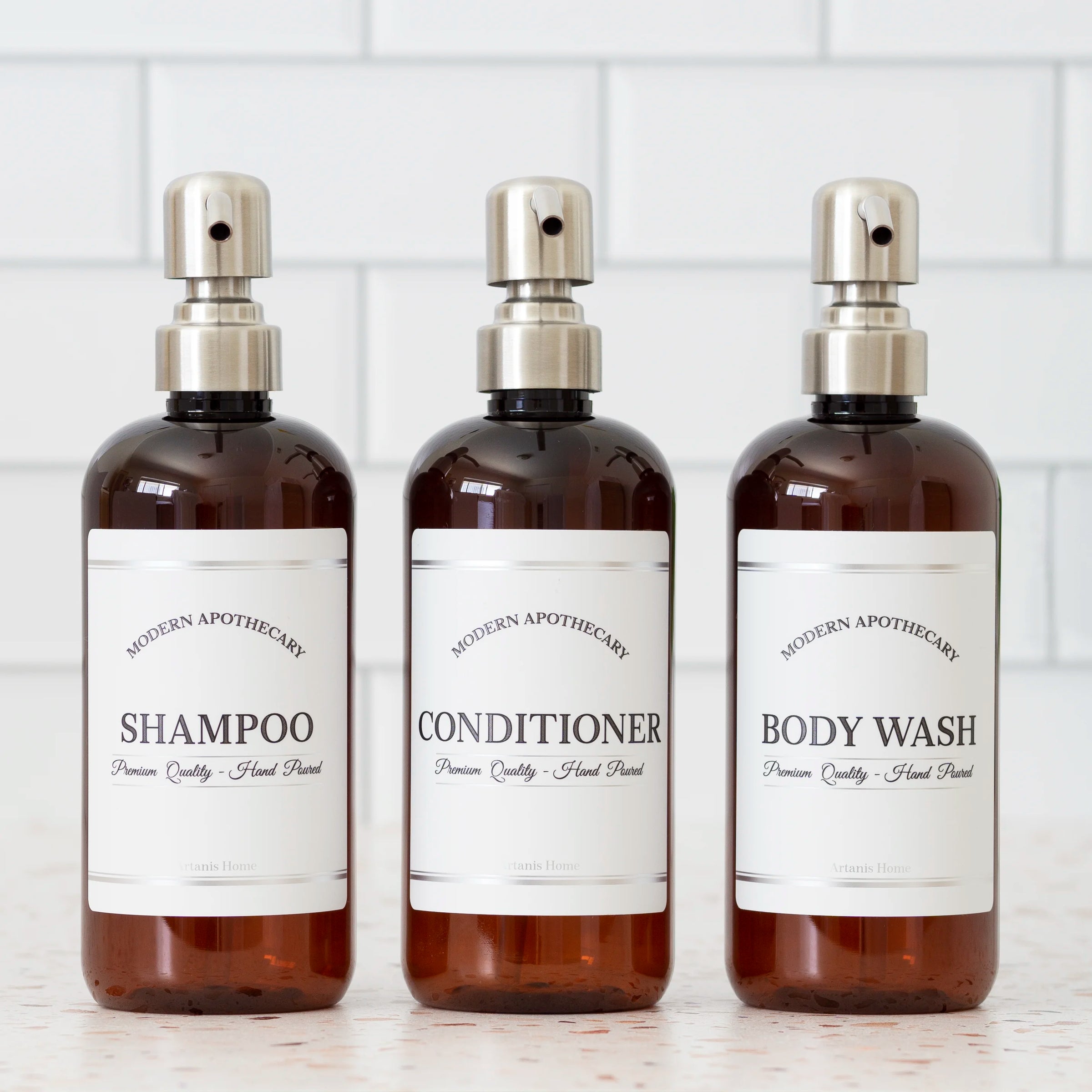 Amber PET set of refillable bottles with steel pumps and coordinated labels for the shower.