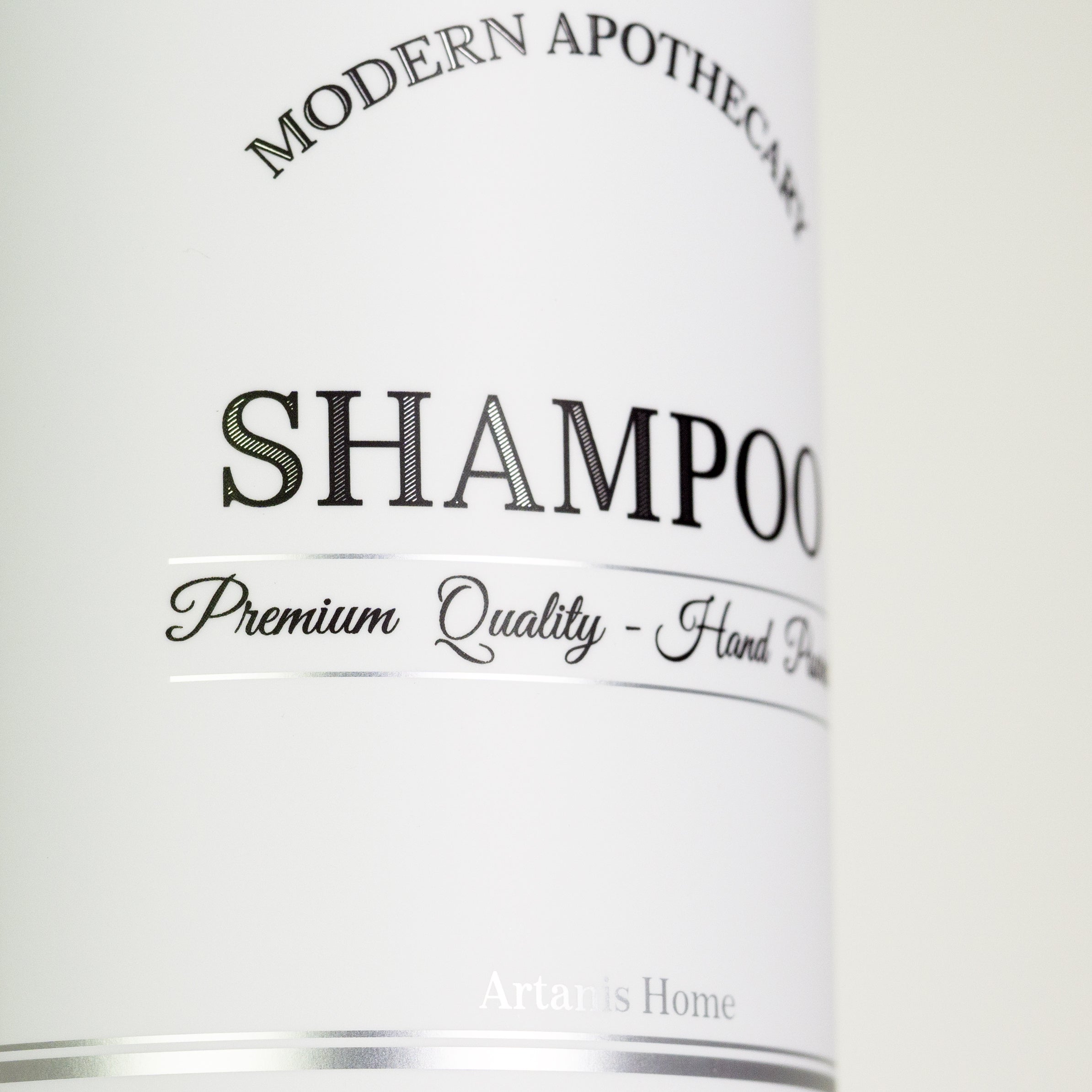 Close-up of the Artanis Home Modern Apothecary label design with silver accents,  refillable shampoo bottle